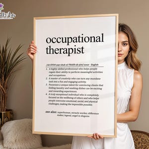 May include: A rectangular framed wall art print featuring a dictionary-style definition of the term occupational therapist in black text on a white background, including phonetic pronunciation and four numbered descriptive points.