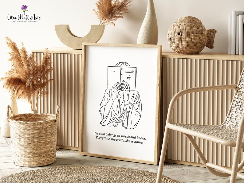 K&ouml;nnte beinhalten: Schwarzwei&szlig;-Linienkunst-Druck einer Person, die ein Buch liest. Der Druck ist gerahmt und h&auml;ngt an einer Wand mit hellem Holzhintergrund. Der Text unter dem Bild lautet "Her soul belongs to words and books. Everytime she reads, she is home."