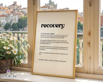 May include: A framed wall art print featuring a dictionary-style definition of the word recovery in black text on a cream background. The text includes phonetic spelling, a noun classification, and several descriptive sentences about personal growth.