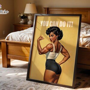 May include: A framed wall art print featuring a muscular person with dark hair in a retro style, wearing a white tank top and black shorts. The person is flexing their arm, and the text YOU CAN DO IT! is printed in white at the top of the yellow background.
