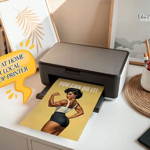 May include: A black and grey desktop printer outputting a yellow poster featuring a muscular person flexing their arm with the text YOU CAN DO IT! A yellow speech bubble graphic with the text PRINT AT HOME OR LOCAL SHOP PRINTER is visible.
