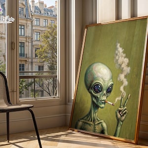 Könnte beinhalten: Ein gerahmter vertikaler Wandkunstdruck, der einen grünen Außerirdischen mit großen dunklen Augen zeigt, die ein Galaxienmuster enthalten. Der Außerirdische hält eine brennende Zigarette in einer Hand und macht mit der anderen ein Friedenszeichen.
