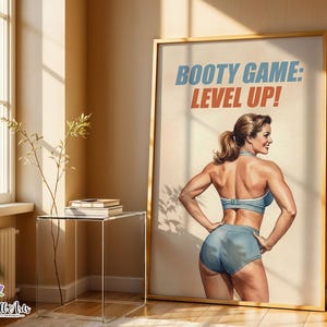 Op de afbeelding: Een ingelijste kunstdruk met een vintage-stijl illustratie van een gespierd persoon in een blauwe sportbeha en korte broek, die met de rug naar de kijker toe staat. De tekst BOOTY GAME: LEVEL UP! staat in blauw en oranje bovenaan.