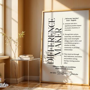 May include: A vertical framed wall art print featuring a dictionary-style definition of the noun Difference Maker. The text is printed in black on a white background, including phonetic spelling, three numbered definitions, and the name William James.