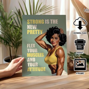 May include: A rectangular wall art print featuring a person with dark curly hair wearing a yellow sports bra, flexing their arm muscles. The background is sage green with the text: STRONG IS THE NEW PRETTY, FLEX YOUR MUSCLES AND YOUR ATTITUDE.