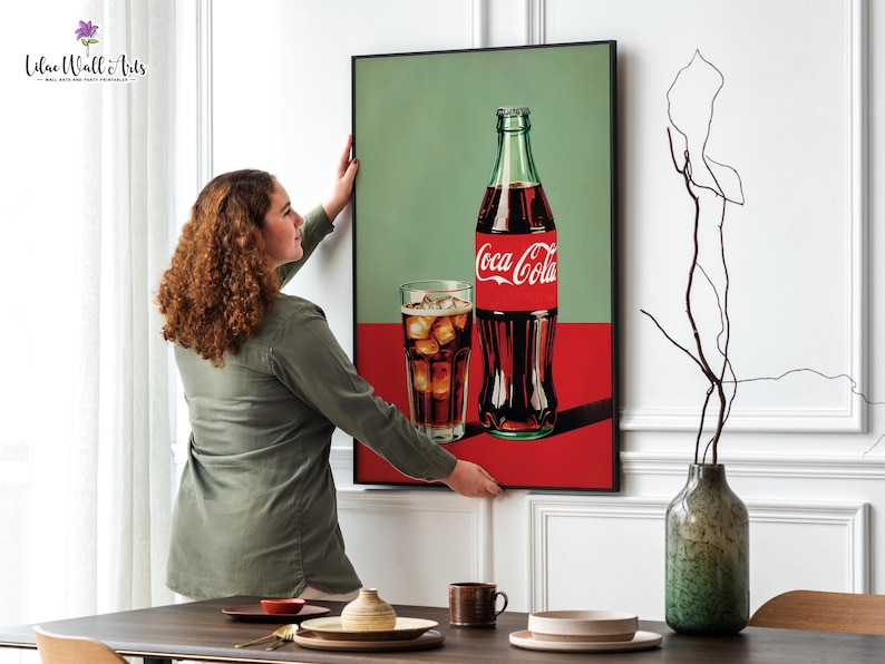 May include: A framed print of a Coca-Cola bottle and a glass of cola with ice. The background is a green and red color scheme.