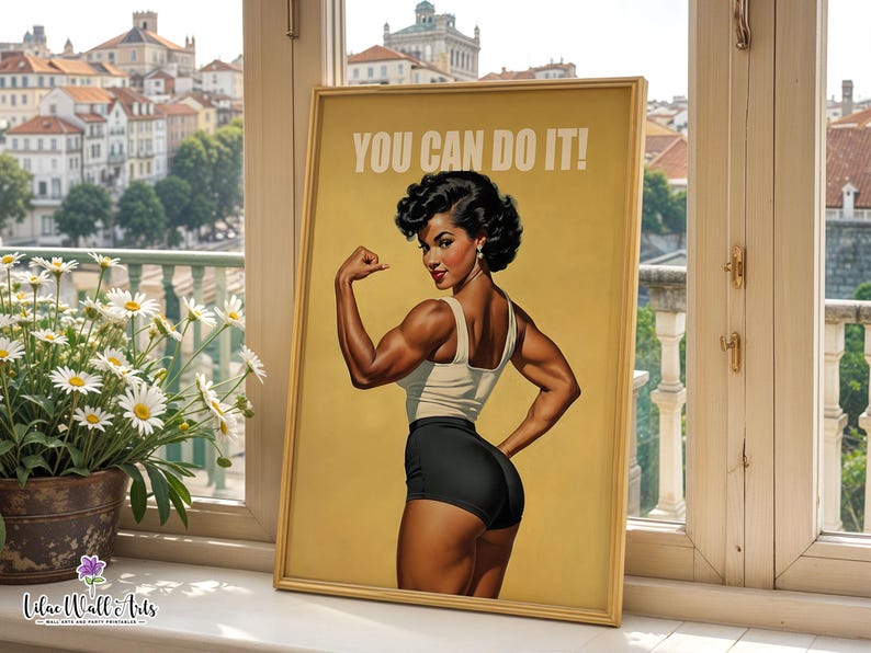 May include: A framed poster featuring a vintage-style illustration of a person with dark hair flexing their arm muscles. The person wears a light-colored tank top and black shorts. The text YOU CAN DO IT! is printed in white at the top of the poster.