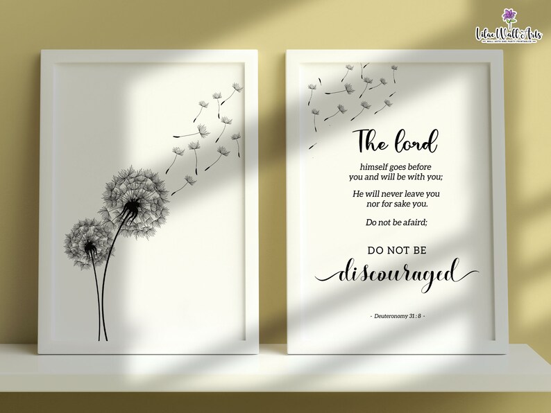 May include: A white framed print featuring a black and white illustration of two dandelions with seeds blowing in the wind. The print also includes a quote from Deuteronomy 31:8: "The Lord himself goes before you and will be with you: He will never leave you nor forsake you. Do not be afraid; DO NOT BE discouraged."