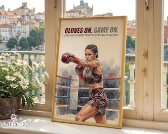 May include: A framed poster featuring a watercolor-style illustration of a boxer in a ring. The text reads GLOVES ON. GAME ON. STRONG WOMEN THROW STRONG PUNCHES. The boxer wears red gloves and a geometric patterned sports bra and shorts set.