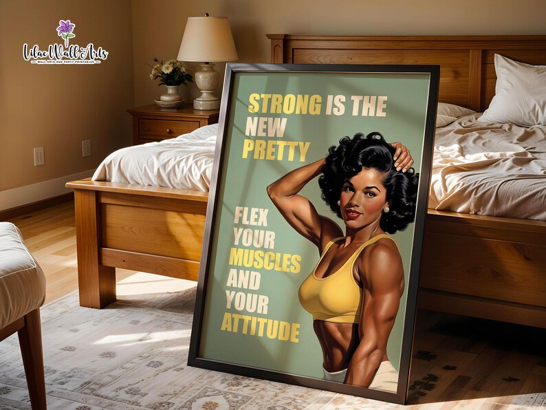 May include: A framed wall art print featuring a muscular person with dark curly hair wearing a yellow sports bra. The sage green background displays the text: STRONG IS THE NEW PRETTY, FLEX YOUR MUSCLES AND YOUR ATTITUDE in bold yellow letters.