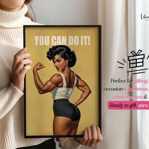 May include: A framed poster featuring a vintage-style illustration of a muscular person flexing their arm, wearing a white tank top and black shorts. The text YOU CAN DO IT! is printed in white at the top against a muted yellow background.