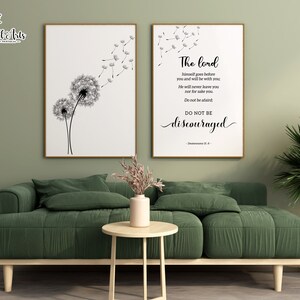 May include: Two framed prints, one with a black and white illustration of two dandelions with seeds blowing in the wind, and the other with a black and white text quote: "The Lord himself goes before you and will be with you. He will never leave you nor forsake you. Do not be afraid. Do not be discouraged." - Deuteronomy 31:8