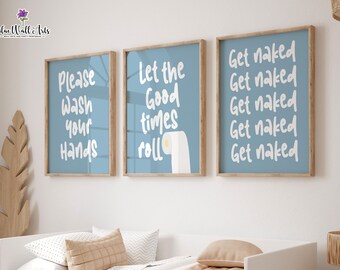 May include: Three blue framed prints with white text. The first print says "Please Wash Your Hands". The second print says "Let the Good Times Roll" with a cartoon toilet paper roll. The third print says "Get Naked" five times.