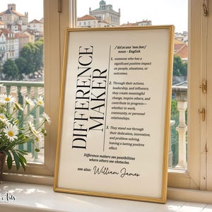 Op de afbeelding: Een ingelijste wandkunstprint met de woordenboekdefinitie van de term "DIFFERENCE MAKER" in zwarte tekst op een witte achtergrond. De print bevat fonetische spelling, drie genummerde definities, een citaat en de naam "William James."