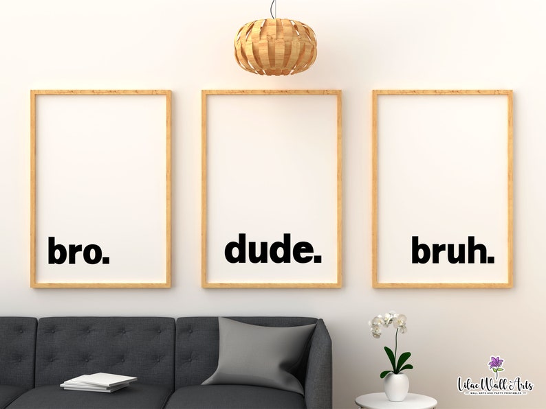 May include: Three framed prints with the words "bro", "dude", and "bruh" in black text on a white background. The frames are light brown wood and are hanging on a white wall.