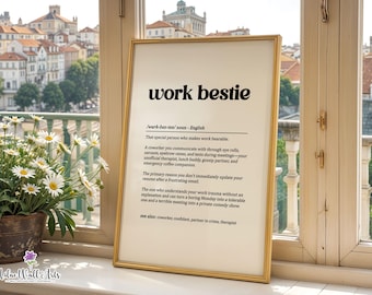 May include: A framed wall art print featuring a dictionary-style definition of the term work bestie in black text on a cream background. The text includes phonetic pronunciation, part of speech, and a humorous description of a coworker.