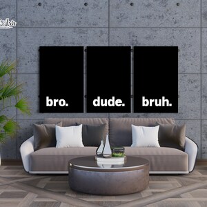 May include: Three black and white canvas prints with the words "bro." "dude." and "bruh." hanging on a gray concrete wall above a brown couch.