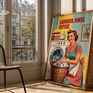 Pode incluir: Um cartaz emoldurado de estilo vintage apresentando uma pessoa com um avental xadrez vermelho e branco ao lado de uma máquina de lavar. O texto LAUNDER, RINSE, REPEAT está impresso no topo. Um cesto de vime com roupas está em primeiro plano.