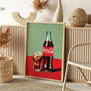 May include: A vintage-style poster featuring a glass of Coca-Cola and a bottle of Coca-Cola. The poster has a green background with a red bottom and the text "Coca-Cola" in red.
