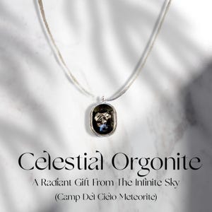 May include: A silver necklace with an oval pendant containing a dark, textured stone. The pendant has a silver border. The text "Celestial Orgonite" and "A Radiant Gift From The Infinite Sky" are displayed below the necklace.
