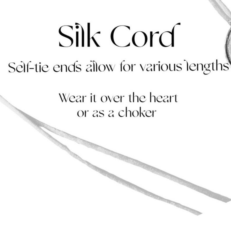 May include: A white silk cord with self-tie ends. The text "Silk Cord" is written in a decorative font. The text "Self-tie ends allow for various lengths" and "Wear it over the heart or as a choker" is also written on the image.