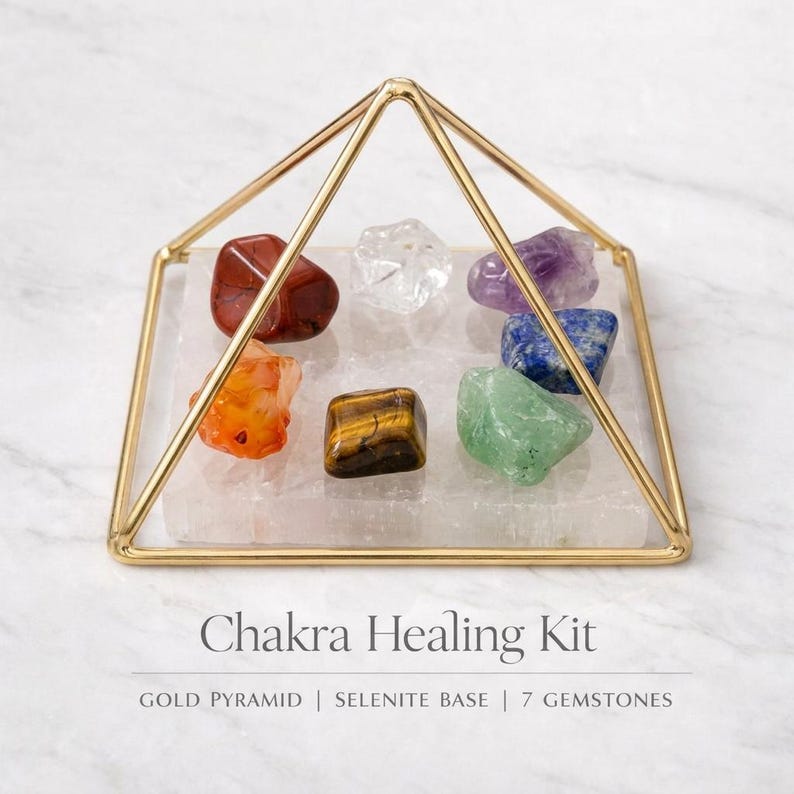 Puede incluir: Un kit de sanaci&oacute;n de chakras con una estructura piramidal de metal dorado, una base cuadrada de selenita y siete piedras preciosas variadas en rojo, naranja, amarillo-marr&oacute;n, transparente, verde, azul y morado. Texto: Chakra Healing Kit.
