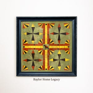 May include: A square wooden game board framed in black, featuring a sage green background with a geometric pattern of red and yellow stripes and black star-like shapes. A small black bird illustration sits in the center. Text reads Baylor Home Legacy.