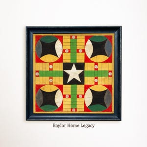 May include: A square board game in a dark frame featuring a central white star on a black square. The board has red, yellow, and green sections with circular corner motifs and grid paths. The text Baylor Home Legacy is printed below.