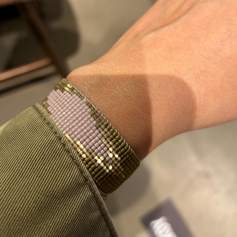 Close-up of the wide Miyuki bracelet on the wrist. Designed in a 2 cm wide triangle pattern. The taupe beads stand out with their shiny appearance under the light.