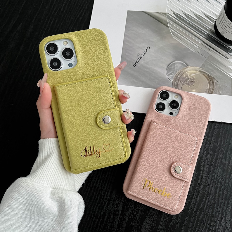 a woman holding a pink and yellow phone case