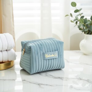 a blue cosmetic bag sitting on top of a table