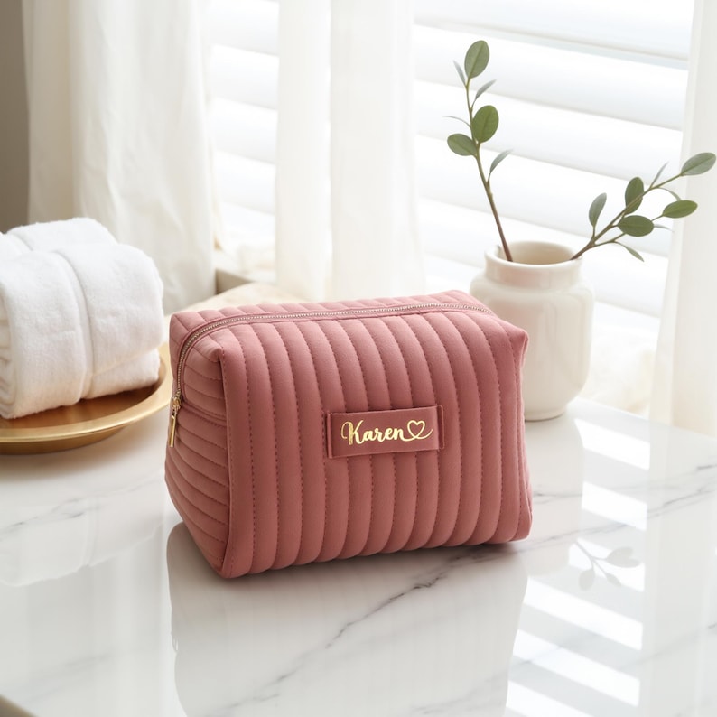 a pink cosmetic bag sitting on top of a white counter
