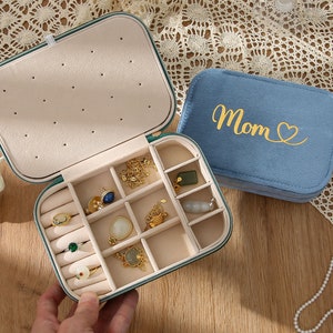 a person is holding a case with jewelry inside