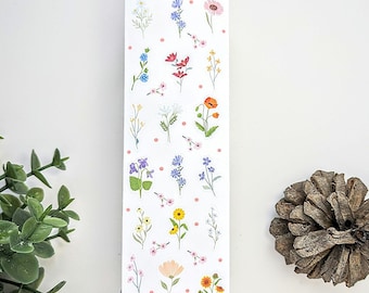 May include: A sticker sheet with a variety of colorful flower designs. The sheet is white with pink polka dots and the text "Sticker Sheet" at the top. The bottom of the sheet has the text "Sticktemis" and a QR code.