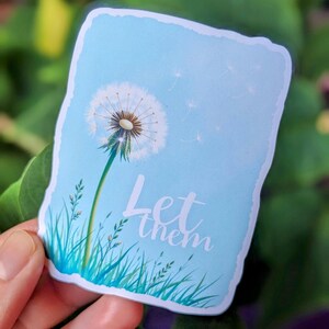 May include: A blue and white sticker with a dandelion and the text "Let them" on a white background.