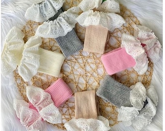Peut inclure: Six paires de chaussettes hautes avec une bordure en dentelle blanche. Les chaussettes sont de différentes couleurs, dont le rose, le beige et le gris.