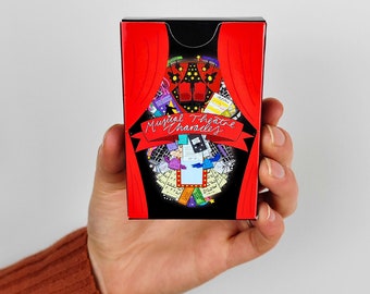 May include: A red box with a black border and a red curtain design. The box has the text "Musical Theatre Charades" on it. The box is filled with various images of musical theatre props and costumes.