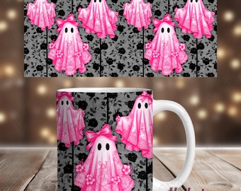 May include: A white ceramic mug and a decorative banner featuring pink ghost designs. The ghosts have bows and floral accents, set against a black floral pattern. The mug has the text "vtbdesigns".
