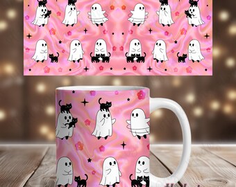 May include: White ceramic mug with a wraparound design featuring cartoon ghosts and black cats on a pink background. The design includes pink flowers and black star accents. The mug has a white handle and the text "vtbdesigns" on the side.