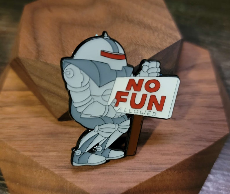 May include: A gray robot with a red visor holding a white sign that says 'NO FUN ALLOWED' in red letters.