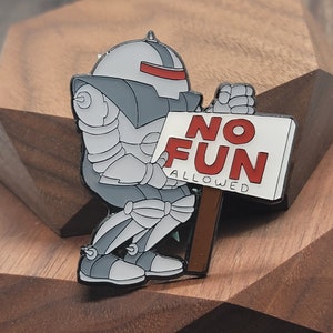 May include: A silver robot holding a white sign that says 'NO FUN ALLOWED' in red letters. The robot is wearing a gray helmet with a red visor.