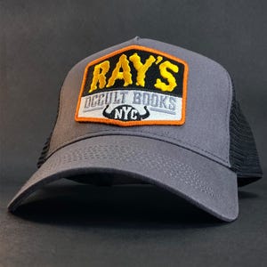 Czapka bejsbolówka retro trucker hat marki Ray&#39;s Occult Books z niesamowitymi świecącymi w ciemności przeszyciami inspirowanymi klasycznym filmem z lat 80. Ghostbusters 2