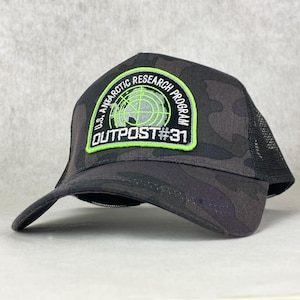 May include: Black camouflage trucker hat with a green and white patch that reads "U.S. ANTARCTIC RESEARCH PROGRAM OUTPOST #31".