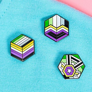 May include: Three enamel pins with different designs representing the gender-neutral pride flag. The pins are on a blue and pink background.