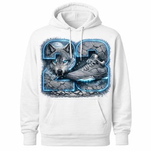 May include: White hoodie featuring a graphic design with the number "23" outlined in blue. The design includes a wolf with glowing blue eyes and a gray sneaker. The background has a cracked stone texture.