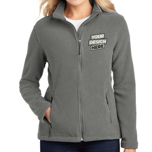 May include: A gray fleece jacket with a zipper closure and two pockets. The jacket has the text "YOUR DESIGN HERE" on the front.
