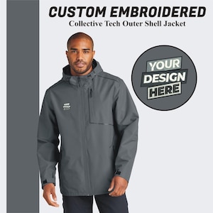May include: A gray hooded jacket with a zipper closure and a pocket on the left chest. The jacket has a black zipper pull and a black logo on the pocket. The text "YOUR DESIGN HERE" is on a white circle with a black border.