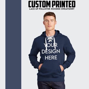 Puede incluir: Sudadera con capucha azul marino con cordones blancos y el texto "YOUR DESIGN HERE" impreso en la parte delantera.