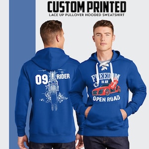 Puede incluir: Sudadera con capucha azul de cord&oacute;n, de cuello redondo, con un gr&aacute;fico de motocicleta blanco en la espalda y un gr&aacute;fico blanco de un coche rojo con el texto "FREEDOM IS AN OPEN ROAD" en la parte delantera.