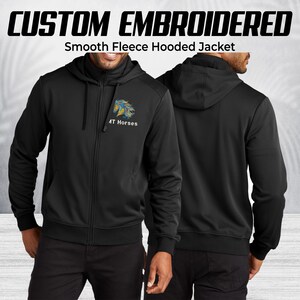 Pode incluir: Casaco com capuz de l&atilde; lisa preta com z&iacute;per completo e capuz. O casaco tem o texto "CUSTOM EMBROIDERED" acima do texto "Smooth Fleece Hooded Jacket". Possui um logotipo de cavalo bordado e o texto "4T Horses" no peito esquerdo.